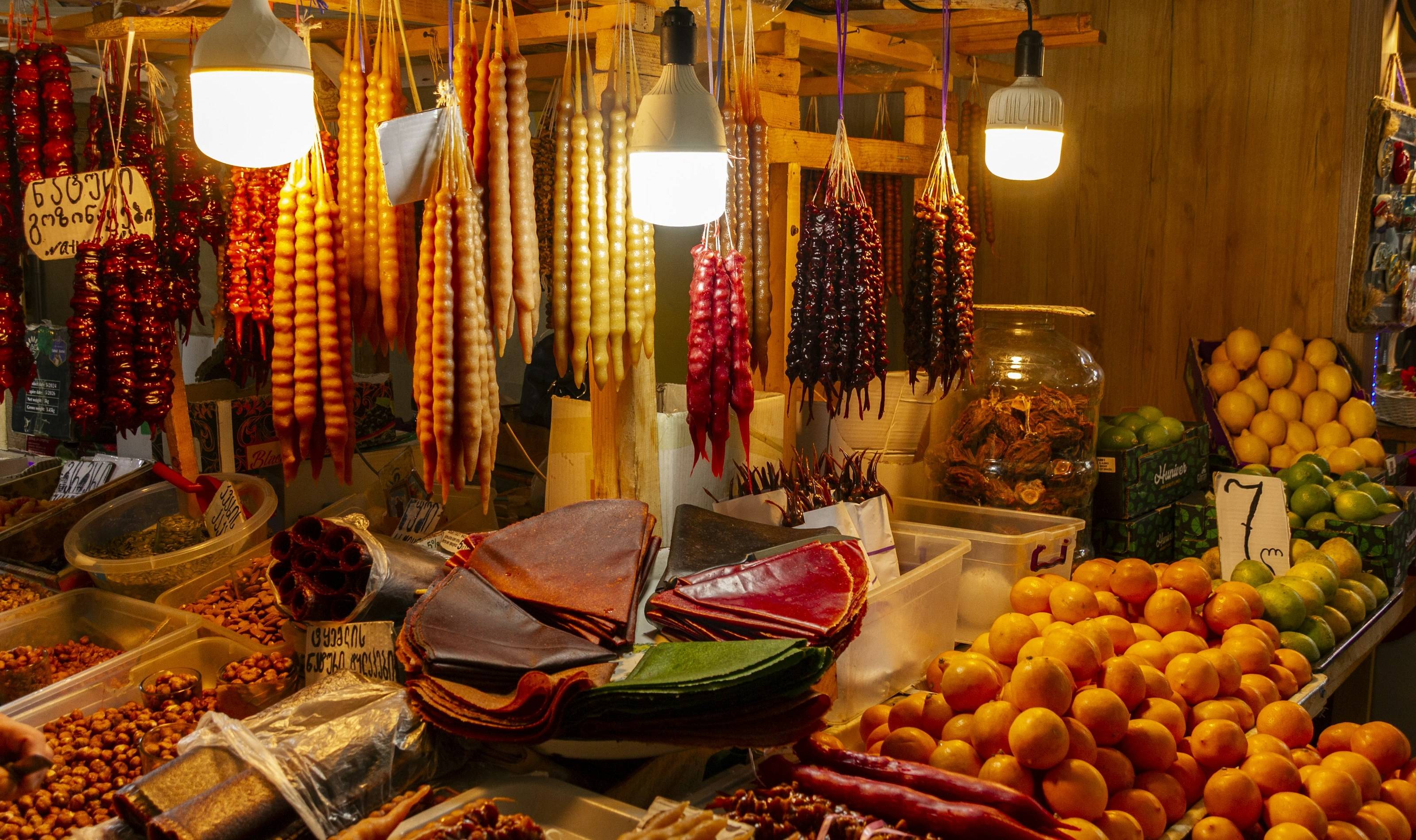 Churchkhela, fruit leather, nuts and oranges at a Georgian market stall
