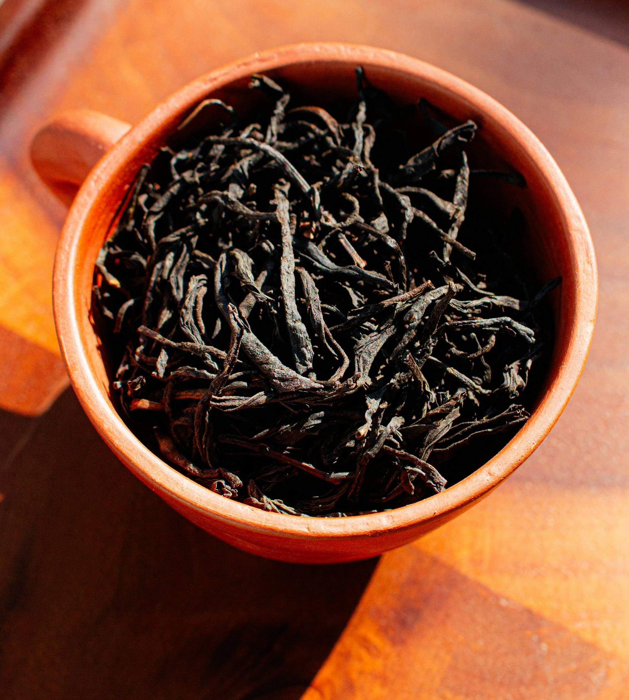 Loose black tea leaves in a clay cup
